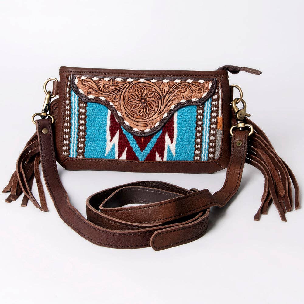 Brown leather crossbody bag with intricate design and tassels on a white background