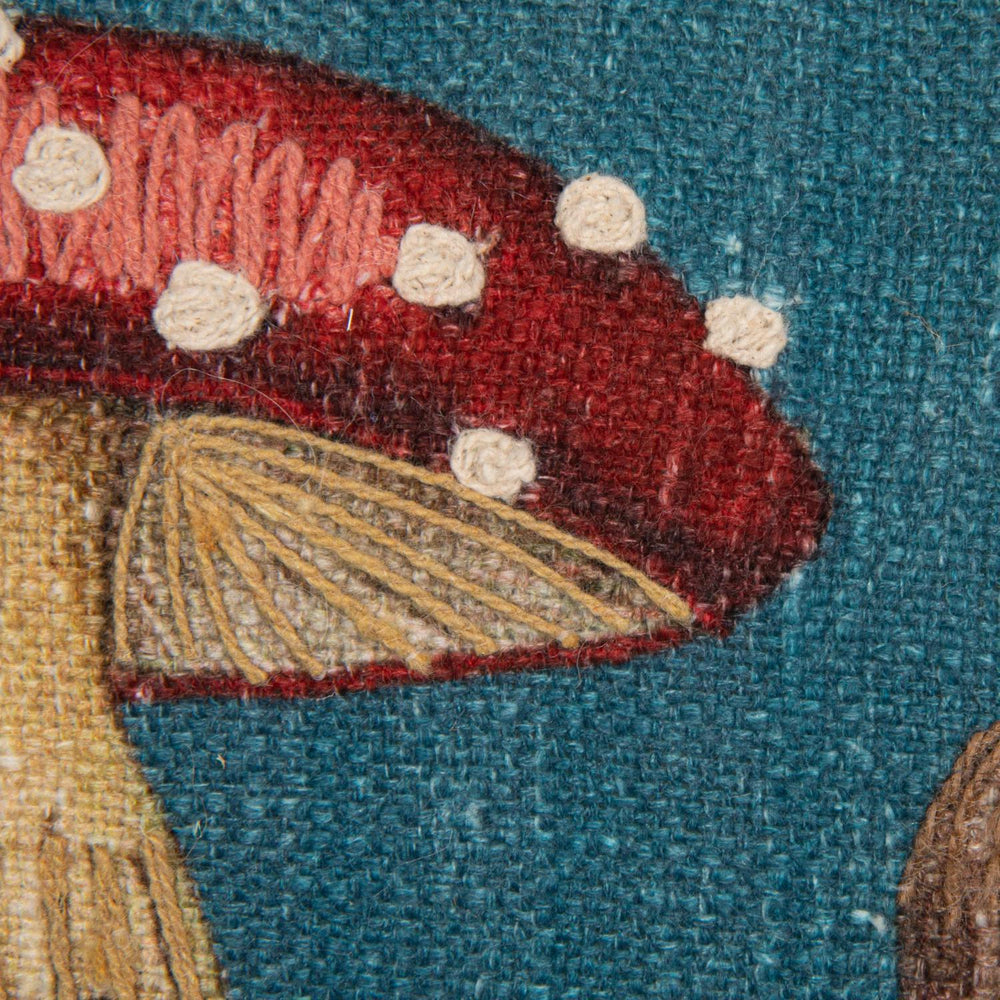 Close-up of a fabric patch with a red mushroom design on a blue background