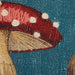 Close-up of a fabric patch with a red mushroom design on a blue background