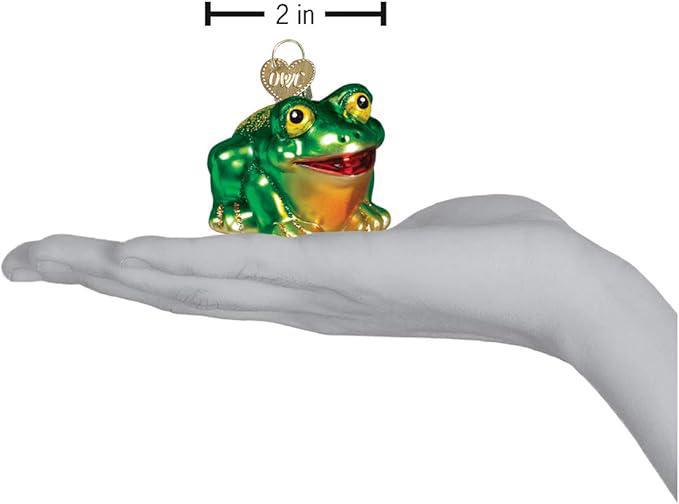 Glass frog ornament held in a hand with measurement label