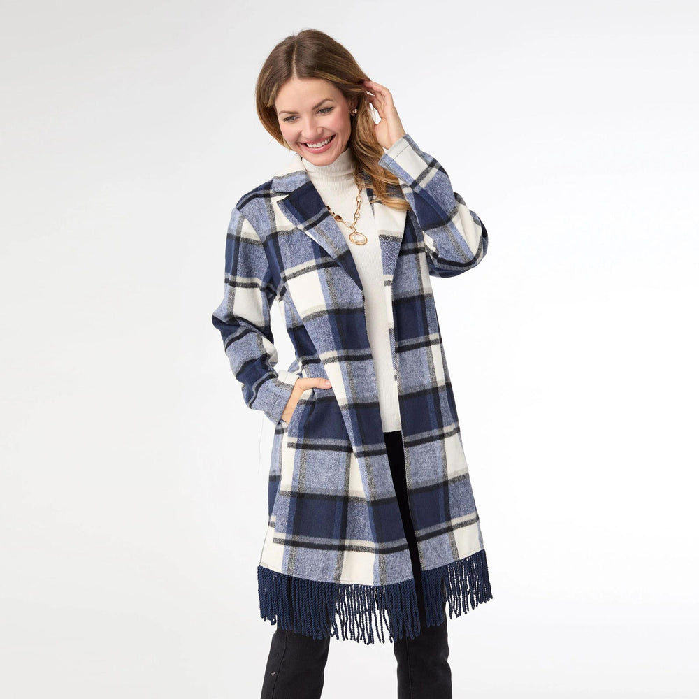 Woman wearing a blue and white plaid coat with fringes on a white background