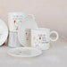 Set of mugs and plates with chicken illustrations and humorous text on a light background