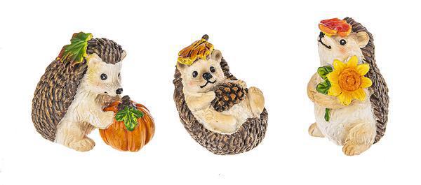 Three decorative hedgehog figurines with autumn-themed accessories on a white background