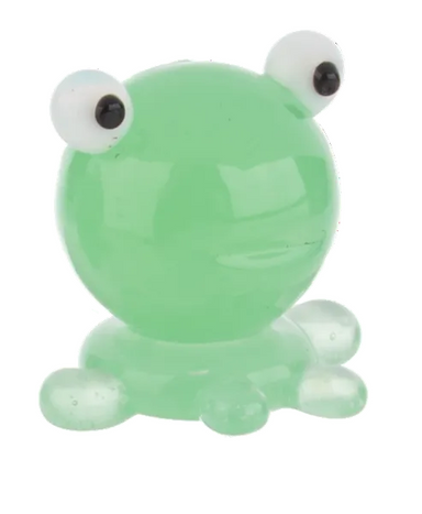 Green glass frog figurine with googly eyes on a white background