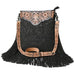 A black fringed crossbody bag with intricate copper-colored tooled leather trim and a black embossed floral pattern on the front, shown against a plain white background.