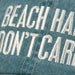 Text 'BEACH HAIR DON'T CARE' embroidered on a denim fabric background
