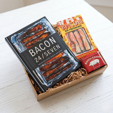 Gift set with 'Bacon 24/Seven' book and bacon-themed items on a white surface