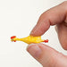 Small yellow chicken figurine held between fingers against a white background