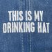 Blue denim fabric with white embroidered text 'THIS IS MY DRINKING HAT'