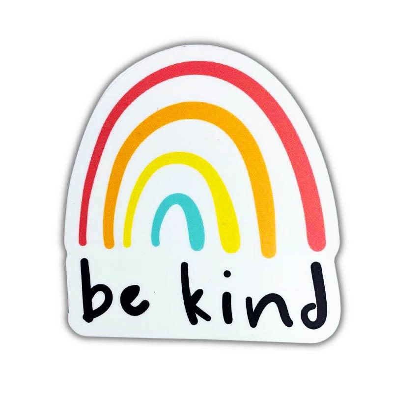 A die-cut sticker featuring a pastel rainbow with the words 'be kind' written in a black handwritten font on a white background.