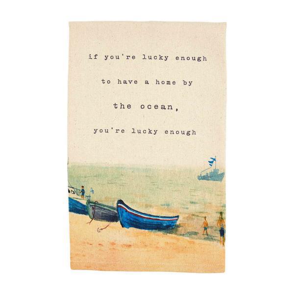 Beach scene with boats and a quote about being lucky to have a home by the ocean.