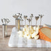 Metal skewers with heart and animal designs on a marble board with cheese.