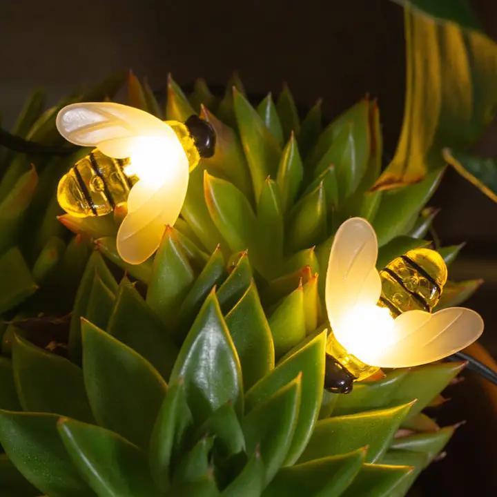 String lights shaped like bees on a green plant