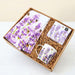 Gift set with a mug, tea towel, and tea bags featuring purple floral design.