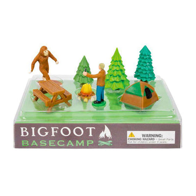 Toy set with Bigfoot and humans around a campsite, including a picnic table, campfire, and tent, on a white background.