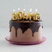Chocolate cake with 'BLow Me' candles on a white background