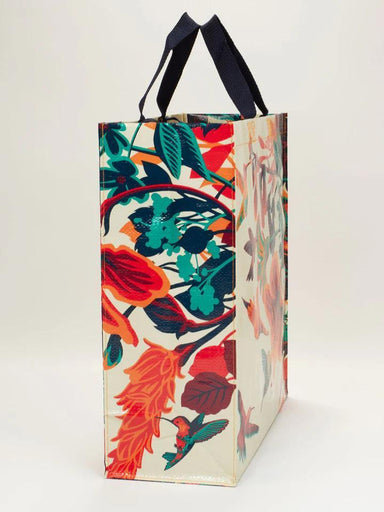 Floral patterned bag with black handles on a white background