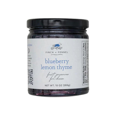 Jar of blueberry lemon thyme preserves with a label on a white background