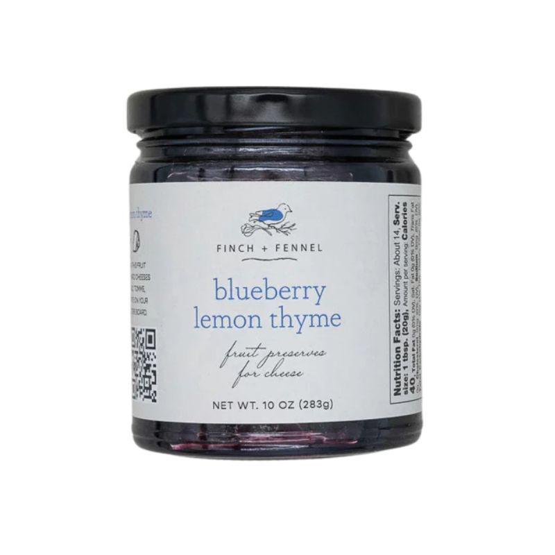 Jar of blueberry lemon thyme preserves with a label on a white background