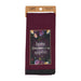 A maroon kitchen towel with a floral 'bone appetit' design, hanging from a kraft paper header card. The towel features a dark central panel with a floral border and the words 'bone appetit' in white, finished with a black lace trim at the bottom.