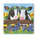 Two cows with flower crowns on a wooden fence with flowers and sunflowers in the background