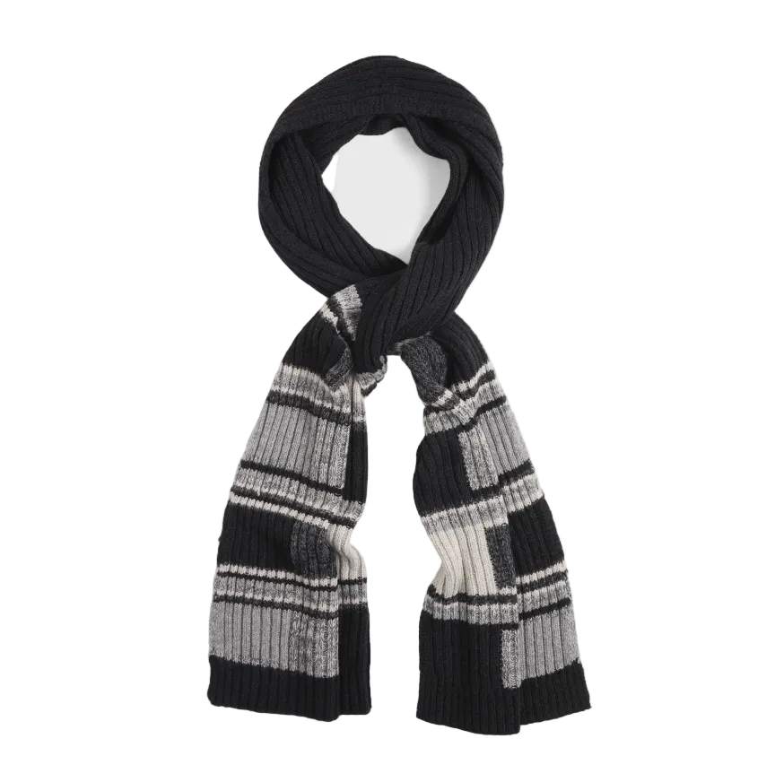 A black knit scarf with a geometric pattern of gray and white blocks, styled in a loop on a light gray background.