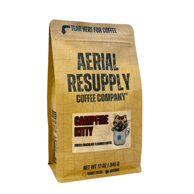 A 12 oz bag of Aerial Resupply Coffee Company Campfire Kitty whole bean coffee, featuring a tan grid-patterned bag with dark green and red text.