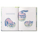 Open book with illustrations of a pink and blue creature in glass bowls on a white background