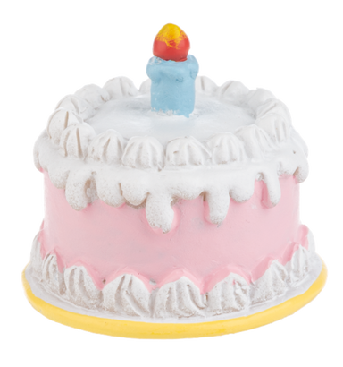 Toy birthday cake with white frosting and a colorful candle on a white background