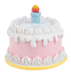 Toy birthday cake with white frosting and a colorful candle on a white background