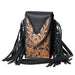Black leather handbag with floral tooled design and black fringes on a white background