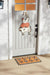 Decorative doormat with cow design in front of a door with a cow and chicken decoration.