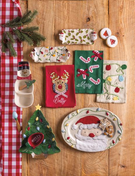 Collection of Christmas-themed kitchen towels and decorative items on a wooden surface.