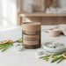 Candle packaging labeled 'Citronella & Lemongrass' with lit tealights on a wooden surface.
