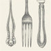 Decorative fork with ornate handles on a light background