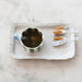 Cup of tea with honey on a white tray on a marble surface