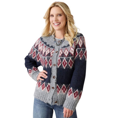 A woman wearing a gray and navy blue button-up cardigan with a red and white geometric diamond pattern, paired with blue jeans against a white background.