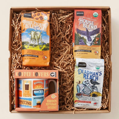 Gift box with coffee packages and a mug on a beige background