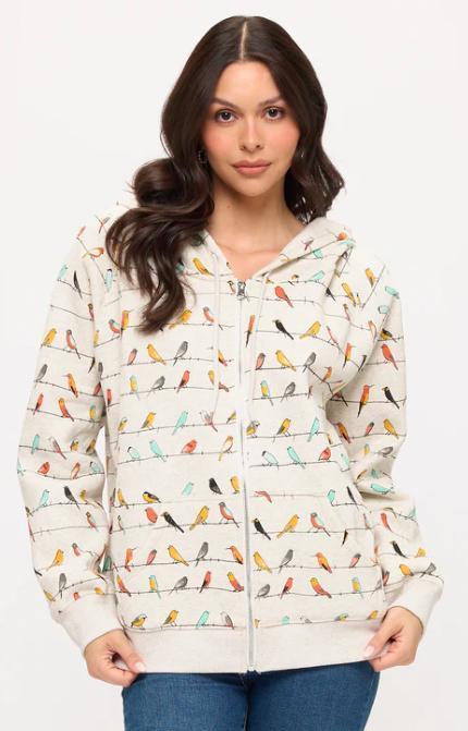 Woman wearing a hoodie with colorful bird pattern on a white background