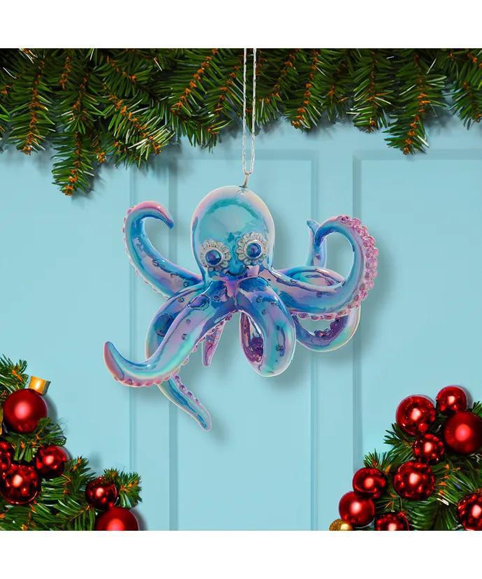 Decorative octopus ornament hanging on a Christmas tree with red ornaments and green branches.
