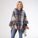 Woman wearing a plaid poncho on a white background