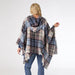 Person wearing a plaid poncho on a white background