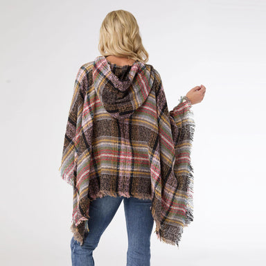 Person wearing a plaid poncho with a white background