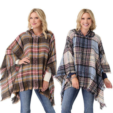 Two women wearing plaid ponchos on a white background