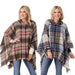 Two women wearing plaid ponchos on a white background