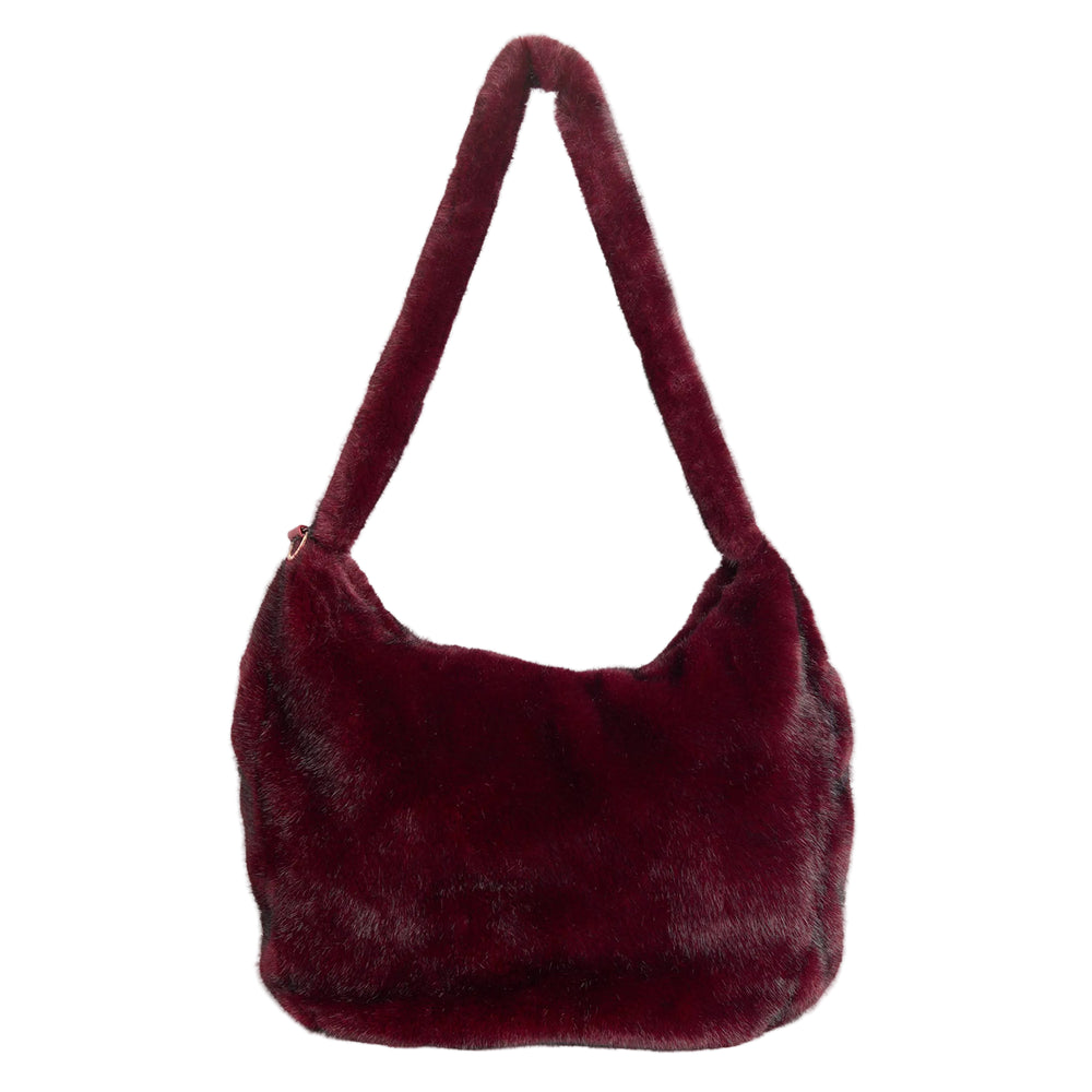 A plush faux-fur shoulder bag in deep burgundy, featuring a single integrated shoulder strap and a slouchy crescent shape, set against a white marble background.