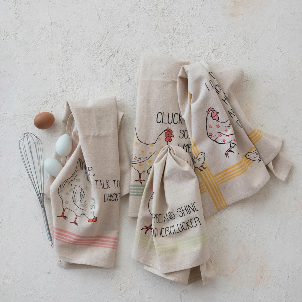 Set of four kitchen towels with chicken designs on a light background