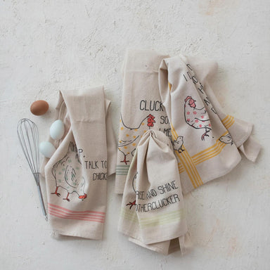 Set of four kitchen towels with chicken designs on a light background