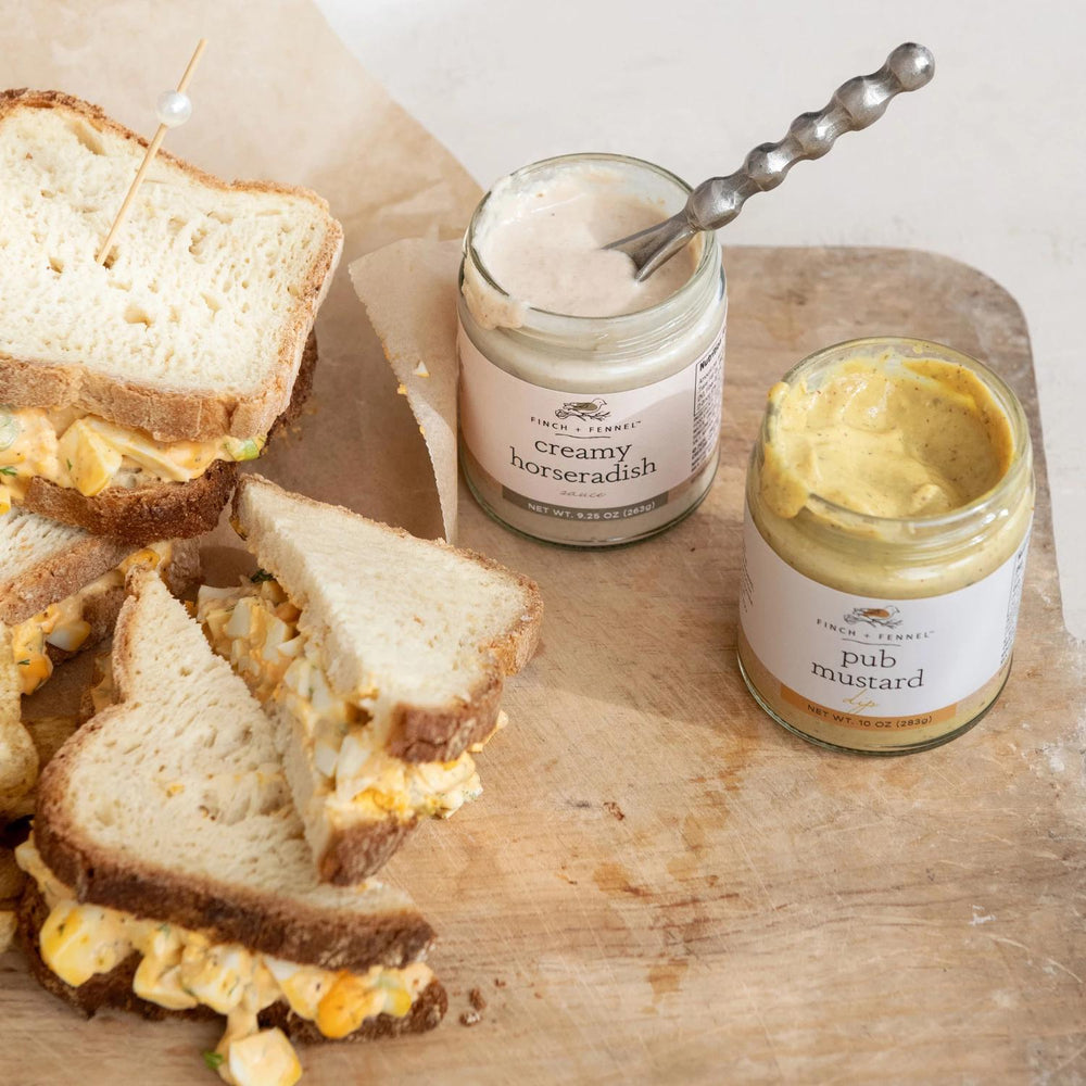 Sandwiches with creamy horseradish and pub mustard on a wooden board.