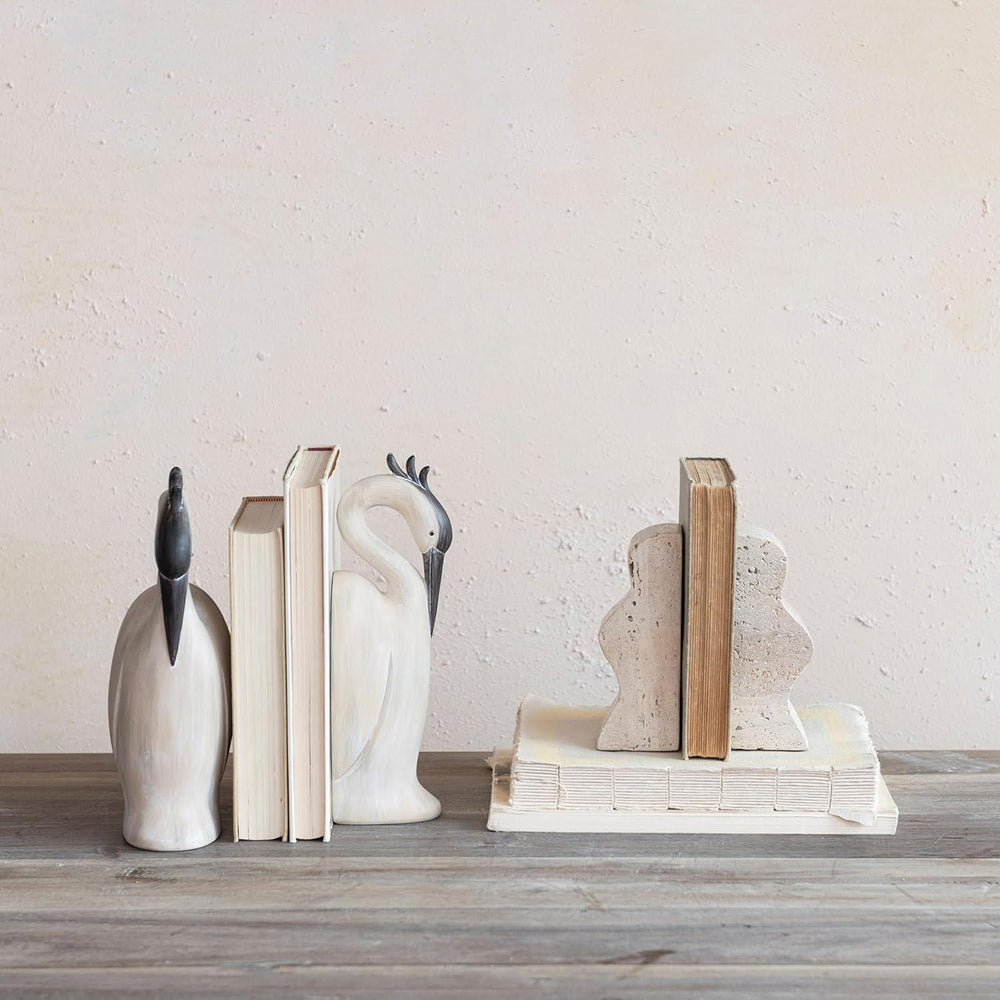 Decorative bookends shaped like birds on a wooden surface with a light background